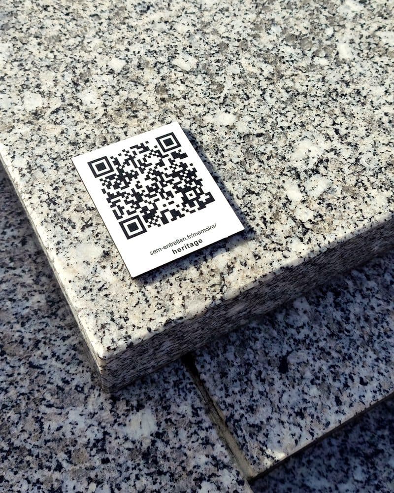 La plaque vue de près : le QR code, et sous lui l’adresse sem-entretien.fr/memoire/heritage.
