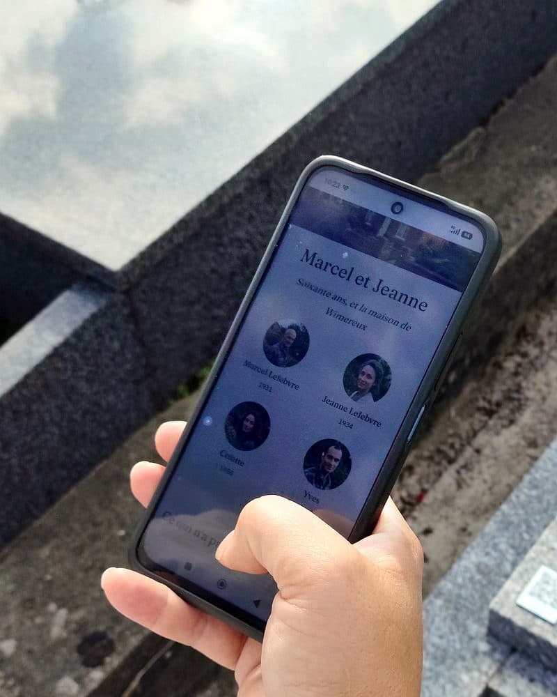 La page « Marcel et Jeanne » ouverte sur le téléphone après le scan du QR code, les quatre visages, la plaque dans le coin.
